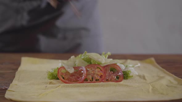 Hands of the Chef in Black Kitchen Gloves Making Shawarma alt