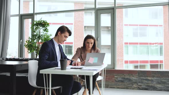 Beautiful young woman working in office with her colleague alt
