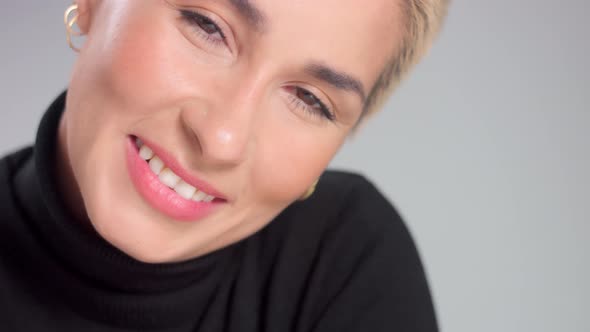 Blonde with Short Haircut in Studio Poses for Camera on Grey Ideal Skin alt