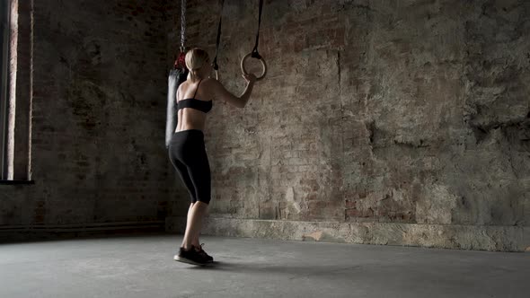 Sporty girl doing flips on sports rings, Young fit woman doing