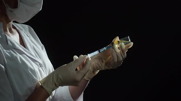Doctor Filling Syringe with Solution on Black Background alt