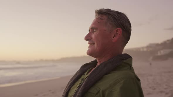 Active senior standing on beach alt