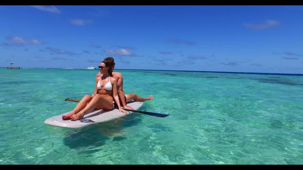Romantic couple engaged on beautiful shore beach journey by clear lagoon with bright sand background alt