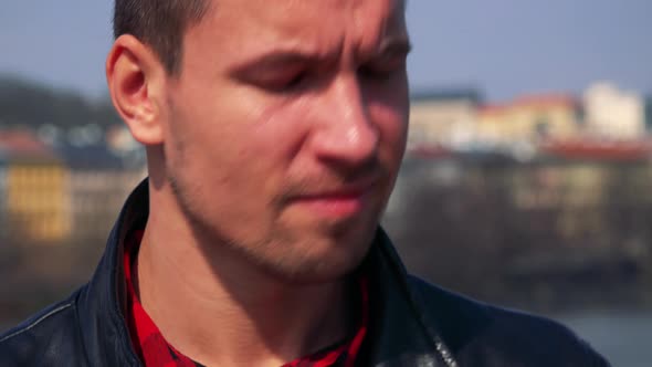 A Young Handsome Man Takes Photos with a Camera - Face Closeup - a Town and the Sky alt