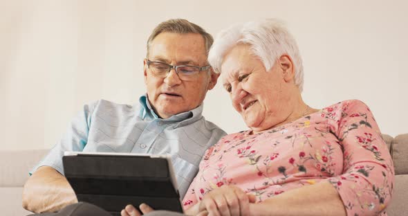 Grandma and Grandpa are Sitting on Couch in Their Cozy Living Room alt
