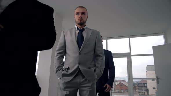 Young manager in a classic suit stands in line for a salary