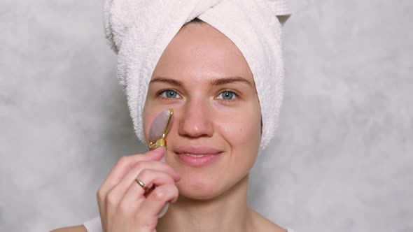 Young Adult Woman Using Rose Quartz Facial Roller
