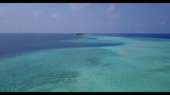 Aerial drone shot travel of tranquil shore beach adventure by blue lagoon with clean sandy backgroun alt