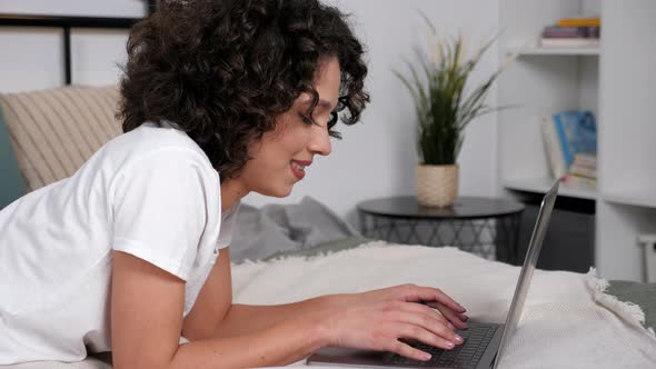 Smiling Hispanic Curly Woman Student Study Uses Laptop Distance Education alt