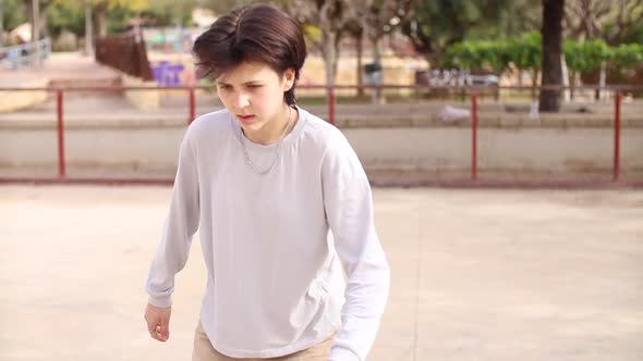 Nonbinary Teenager Riding Skateboard in Empty Skatepark
