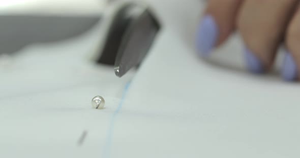 beautiful female hands with purple manicure ring cut fabric with scissors alt