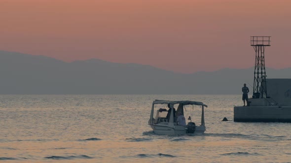 Motor boats sailing in quiet sea near the quay, evening scene alt