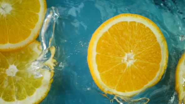 Fresh Oranges Falls in Water Juice with Huge Splashes