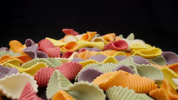 Creative Multicolored Pasta Farfalle on a Black Background in Perspective Background alt