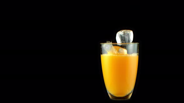Super Slow Motion Shot of Ice Cubes Falling Into Glass of Orange Juice at 1000 Fps alt