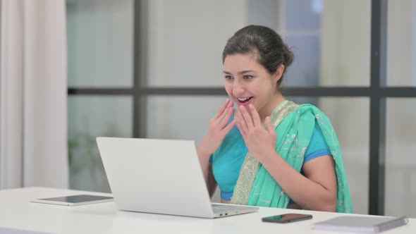 Indian Woman Celebrating Success While Using Laptop in Office alt