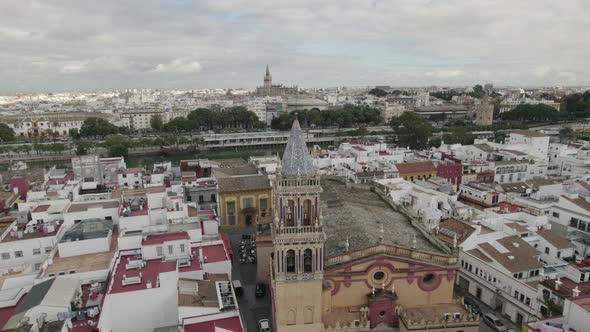 Orbiting over Historic Church of St. Anne facade, Triana district, Seville cityscape