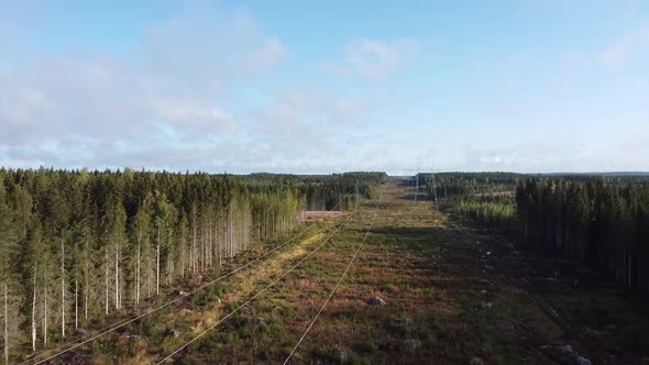 Drone shot flying over fields and forests with telephone lines in Finland alt