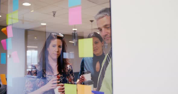 Business people discussing over sticky notes in a modern office 4k