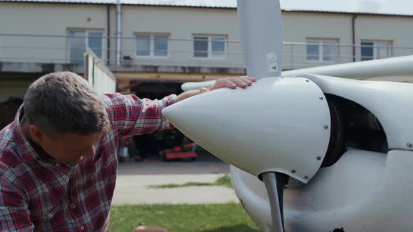 Aviator Fixing Airplane Propeller Smiling Enjoying Preflight Process Close Up alt