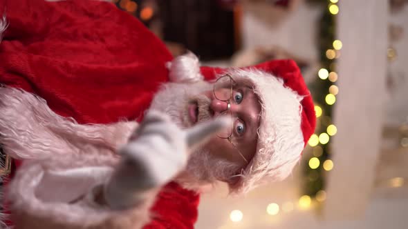 Portrait Funny Santa Claus in Glasses Sitting in His Rocker Near Christmas Tree. Christmas Spirit
