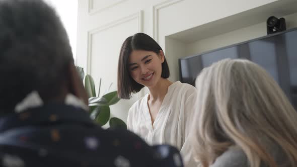Slow motion of Chinese businesswoman smiling in creative business meeting with female colleagues alt