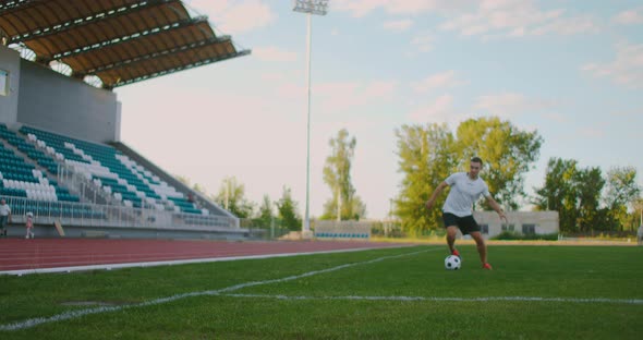 A Professional Football Player in Uniform on the Football Field of the Stadium Makes a Kick alt