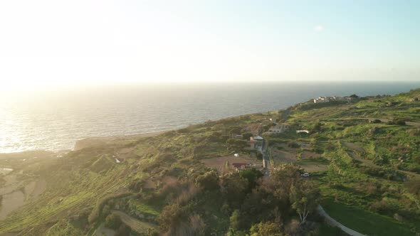 AERIAL: Reveal Shot of Mediterranean Sea and Green Hill near Coastline of Malta in Winter