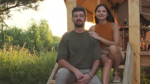 Spouses Posing Sitting by Glamping alt
