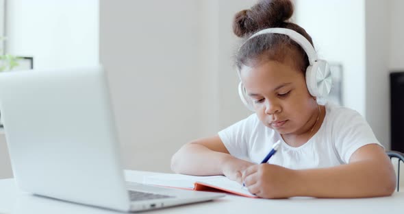 Afro American Kid Girl School Pupil Wearing Headphones Studying Online From Home Watching Web Class alt