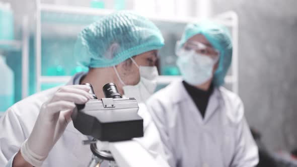 Scientist team has researching in the laboratory microscope and analysis results in the laboratory alt