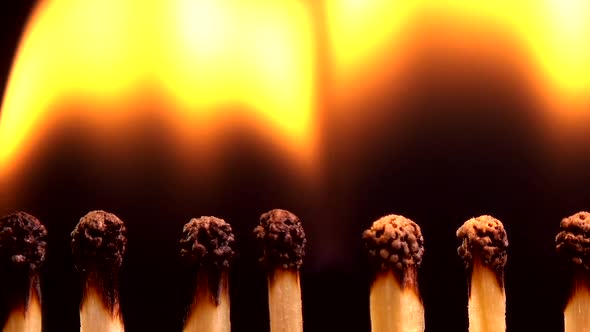 Burning matches on a black background. alt