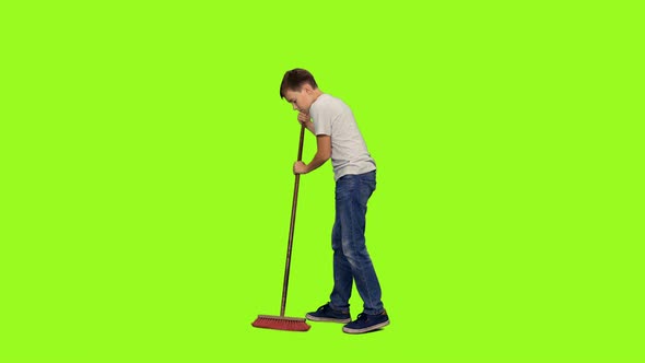 Teen Boy Sweeps the Floor with Mop