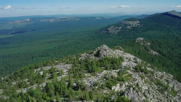 Aerial View of Mountain Range with Pano of Overgrown Slopes and Stone Peaks