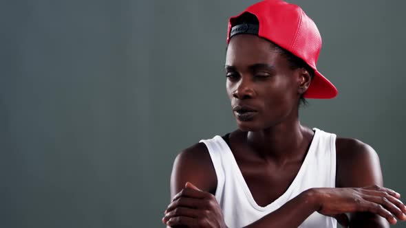 Androgynous man posing with red cap alt