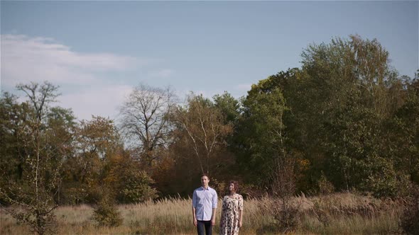 Young Couple Walking on a Meadow alt