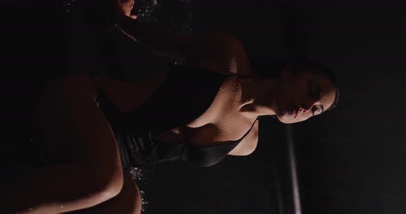Sexy Woman in Swimsuit Lying Under Rain in Black Studio Vertical Video