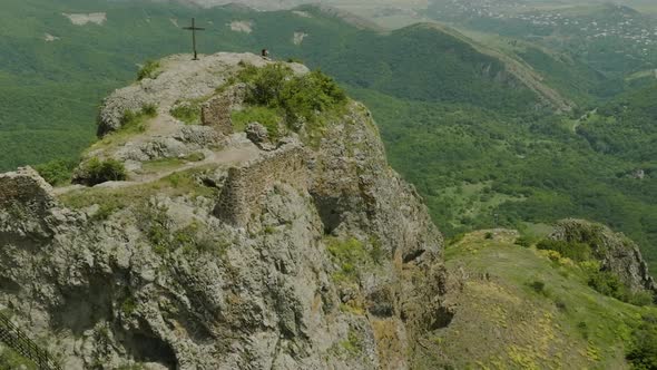 Majestic scenery of the Azeula Fortress and a cross against a broad wilderness. alt
