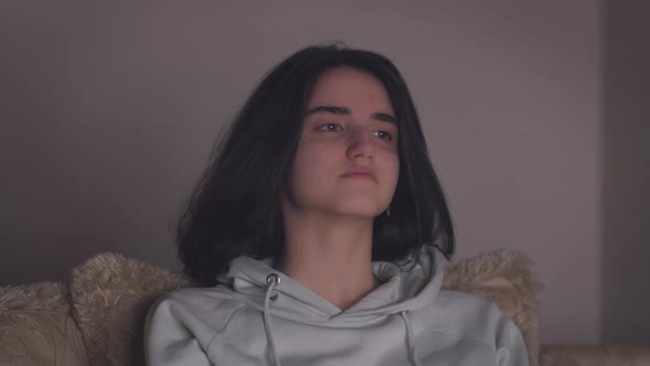 Girl with black hair watching a movie at night alone alt