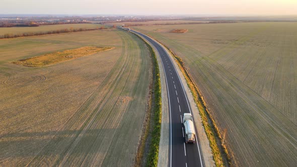 Aerial View of Cargo Trucks Driving on Highway Hauling Goods alt