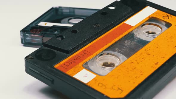 Two Vintage Audio Cassette Rotates on White Background alt