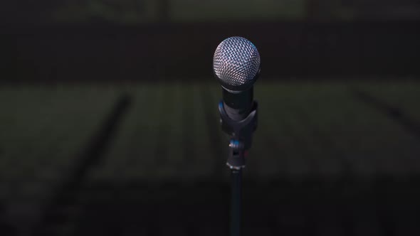Microphone for Solemn Ceremony or Concert Stands on Stage Dark Background Closeup alt
