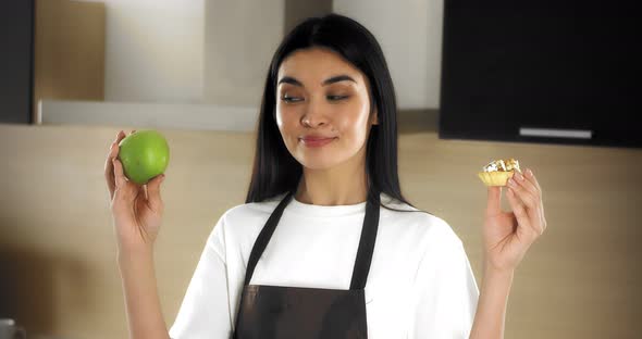 Beautiful Woman Makes a Choice in Favor of Healthy Food Bites a Green Apple