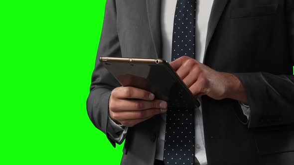 Caucasian man using a digital tablet on green background