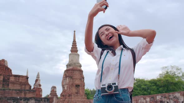 Young Asian backpacker blogger woman casual take selfie video call on mobile phone.