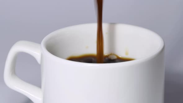 Pouring Black Coffee Into a White Cup alt