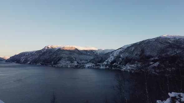 Aerial showing Vaksdal from Langhelle - Snowy landscape and fjords in early morning alt