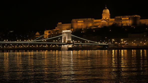 Lighted Szechenyi bridge and royal palace on Buda hill Budapest 4K 2160p UltraHD footage - Chain Bri alt