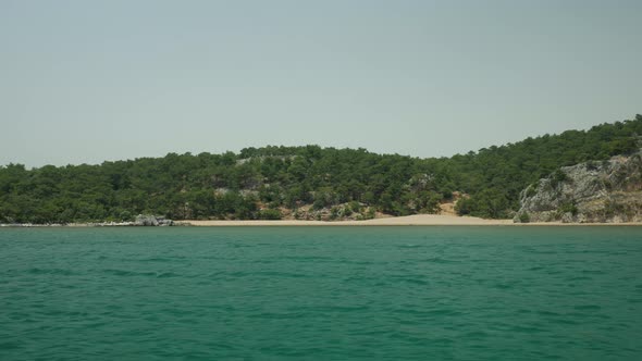 Swim and look at the lonely beach from the sea alt