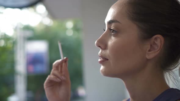 Woman Smoking a Cigarette Outdoors  alt